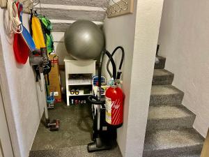 a room with a fire extinguisher and a ball and stairs at Magnifique Maison près du centre in Nendaz