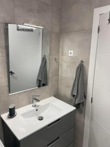 a bathroom with a white sink and a mirror at Casa Los Urrutias in Los Urrutias
