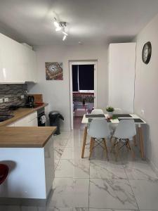 uma cozinha com armários brancos e uma mesa e cadeiras em Casa Los Urrutias em Los Urrutias