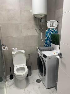 a bathroom with a toilet and a washing machine at Casa Los Urrutias in Los Urrutias