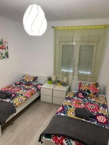 a bedroom with two beds and a chandelier at Casa Los Urrutias in Los Urrutias