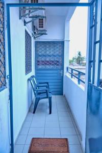 a blue door with a chair on a balcony at Appartement Cosy & Chill in Douala