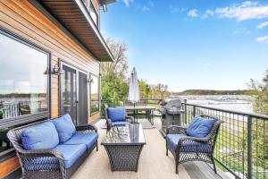 a porch with chairs and a table with a view of the water at Lakeshore Vermont in Colchester