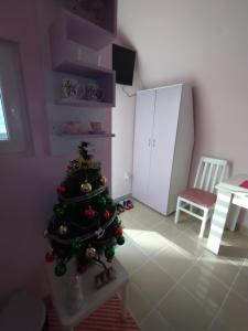 a christmas tree in a living room with a table at Yellow story in Vrdnik