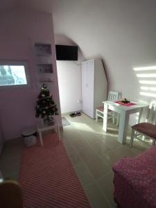 ein Wohnzimmer mit einem Weihnachtsbaum und einem Tisch in der Unterkunft Yellow story in Vrdnik