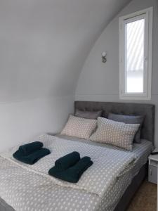 ein Bett mit zwei Kissen und einem Fenster in der Unterkunft Yellow story in Vrdnik