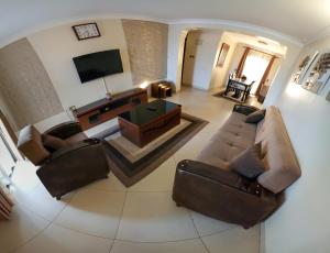 坎帕拉Eric Wilkins Apartments的带沙发和电视的客厅