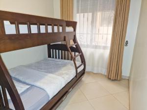 坎帕拉Eric Wilkins Apartments的带窗户的房间里的一张双层床