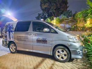 a silver van parked on a brick street at Eric Wilkins Apartments in Kampala