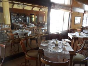 a dining room with tables and chairs in a restaurant at Hotel Rey Arturo Burgos in Villagonzalo-Pedernales