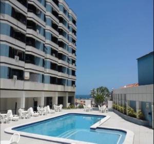 a swimming pool in front of a building at Excelente localização na Barra -Climatizado-Garagem in Salvador