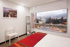 1 dormitorio con cama y ventana grande en PapaGayo City, en Quito