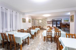 a dining room with white tables and chairs at Dom Pod Lipą in Rymanów-Zdrój