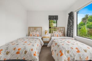 um quarto com 2 camas e uma janela em Regent Retreat - Martinborough Holiday Home em Martinborough