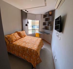 a small bedroom with a bed and a desk at Excelente localização na Barra -Climatizado-Garagem in Salvador