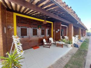 Chalé aconchegante na Barra de São Miguel في بارا دي ساو ميجيل: منزل مع فناء مع باب خشبي