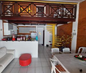 ein Wohnzimmer mit einem Tisch und einer Küche in der Unterkunft Chalé aconchegante na Barra de São Miguel in Barra de São Miguel
