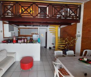 ein Wohnzimmer mit Tisch und Küche in der Unterkunft Chalé aconchegante na Barra de São Miguel in Barra de São Miguel