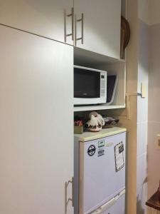 a microwave on top of a refrigerator in a kitchen at Apto Península excelente ubicación** in Punta del Este