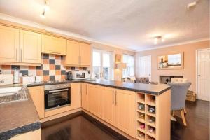 a kitchen with yellow cabinets and a black counter top at Modern three Bedroom House in great Durham City in Durham