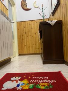 un podio con una alfombra feliz de vacaciones en el suelo en Casa vacanze the coste, en San Chirico Raparo