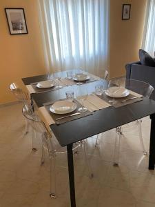 - une table à manger avec des chaises et des verres à vin dans l'établissement Appartamento - Isola, à Milan