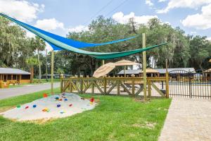 a playground with a slide and a blue net at Idlewild Lodge and RV Park in Lake Panasoffkee
