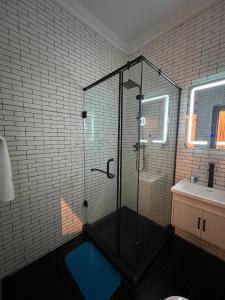 a bathroom with a glass shower with a blue floor at Bricks Residence in Lekki