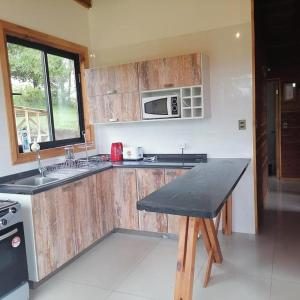 cocina con armarios de madera y encimera en Casa en Villarrica con vista al Volcán, en Molco