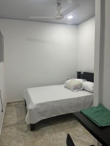 a white bedroom with a bed and a ceiling at Hotel RIO Y SOL DORADO in La Dorada
