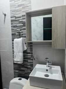 a bathroom with a sink and a toilet and a mirror at Hotel RIO Y SOL DORADO in La Dorada