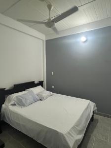 um quarto com uma cama e uma ventoinha de tecto em Hotel RIO Y SOL DORADO em La Dorada