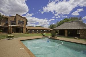a swimming pool in front of a house at Peter's Guesthouse in Pretoria
