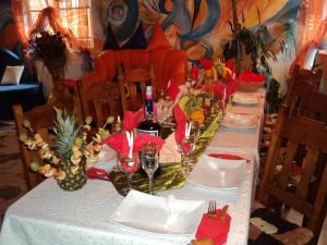 un lungo tavolo con tovaglia bianca e bicchieri da vino di Pensiunea Alexandra & Diego a Predeal
