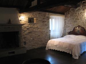 1 dormitorio con cama y pared de piedra en Locanda La Campana, en Agnone