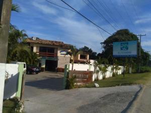 a sign in front of a house on a street at Pousada Aldeia Mar in Ilhéus