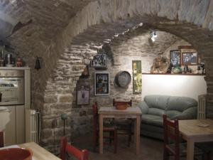 a living room with a couch in a stone wall at Locanda La Campana in Agnone