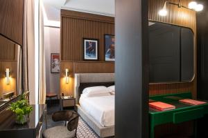 a bedroom with a bed and a green desk at Umiltà 36 in Rome