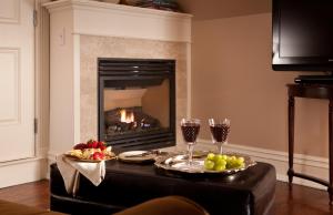 a living room with a fireplace and a table with glasses of wine at The Tower Cottage in Point Pleasant Beach