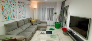 ein Wohnzimmer mit einem Sofa und einem TV in der Unterkunft VISION RELAX HOME in Playa del Ingles