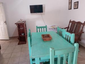 Habitación con mesa verde con sillas y TV. en Departamento Pueyrredón en Santa Rosa