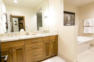 a bathroom with a sink and a mirror and a tub at Deluxe King Room with Deck Hotel Room in Park City