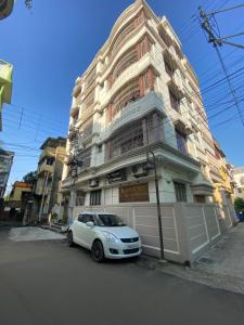 a white car parked in front of a building at Krishna Kunja " A Quiet & Peaceful Stay " in Kolkata