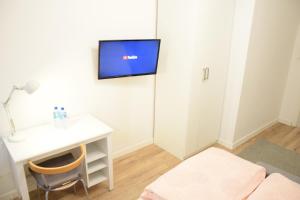 a living room with a desk and a tv on the wall at Private rooms in the Old Town in Gdańsk