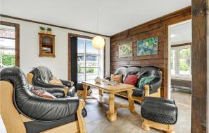 a living room with leather chairs and a table at 6 Bedroom Cozy Home In Gudhjem in Gudhjem