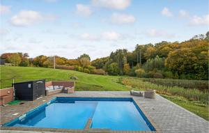 a swimming pool in the middle of a yard with a field at 6 Bedroom Cozy Home In Gudhjem in Gudhjem