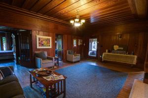 a living room with wood paneling and a chandelier at The Captains Quarters in Fort Bragg