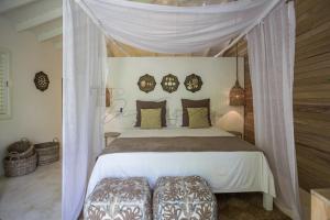 ein Schlafzimmer mit einem weißen Bett mit Baldachin in der Unterkunft Mahona Boutique Hotel in Las Terrenas