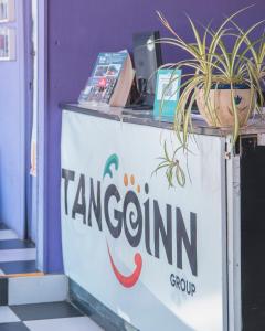 a sign for a tangerine shop with a potted plant on it at Tangoinn Hostel Downtown in San Carlos de Bariloche