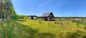 a small building in the middle of a field at Prosportówek - Bronków - Domek nad Jeziorem w Otoczeniu Pięknych Lasów in Bronków